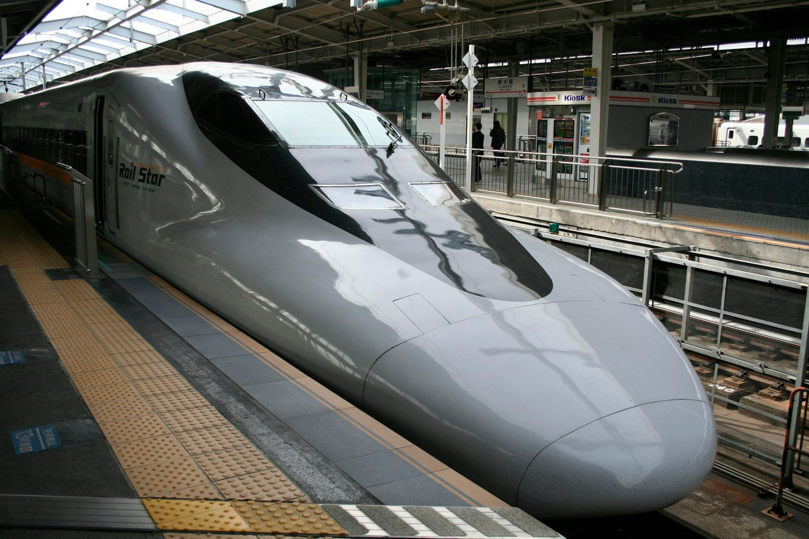 A shinkansen bullet train pulling into a station platform in Japan