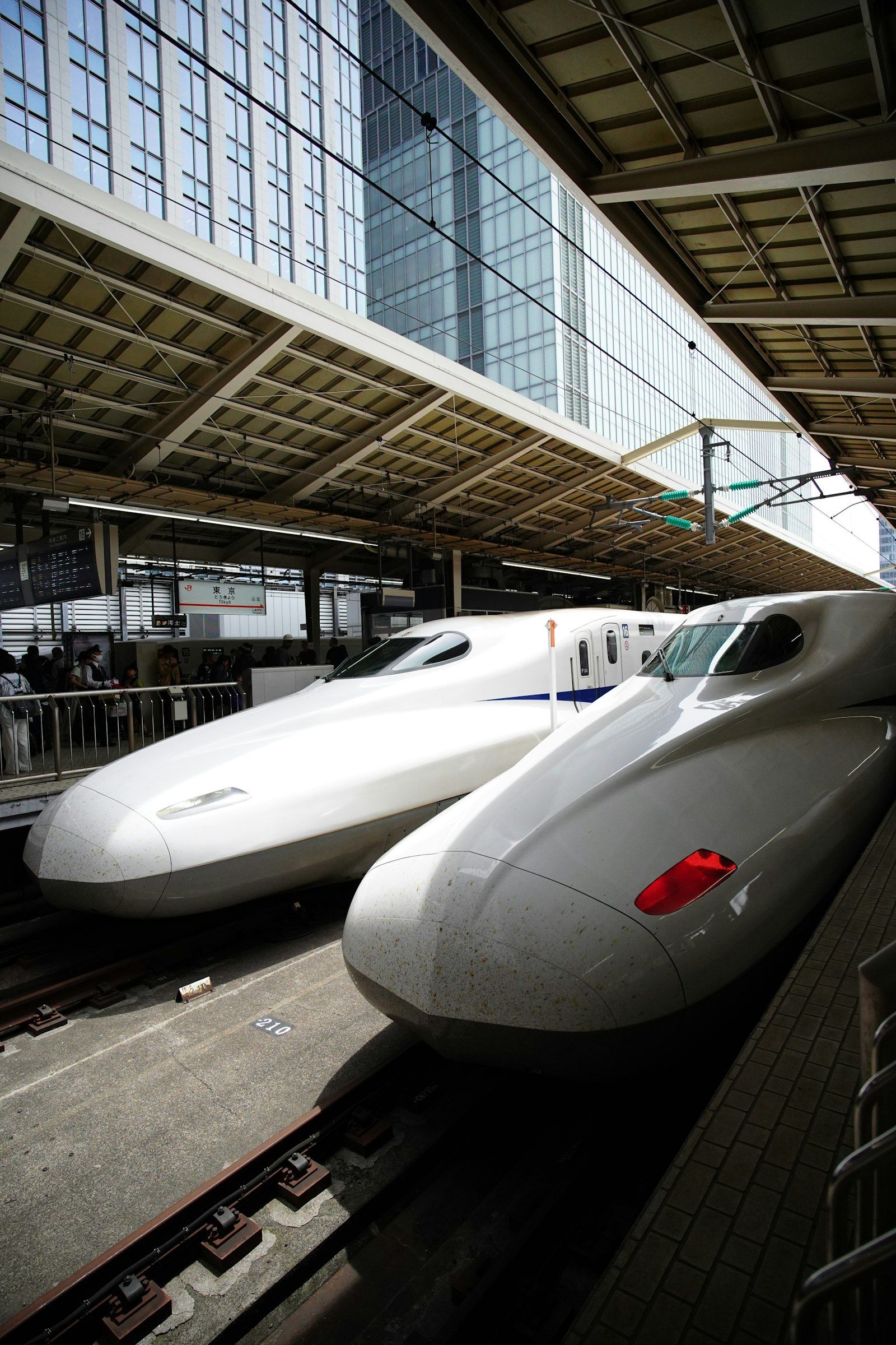 Two shinkansen bullet trains waiting side by side at a station in Japan