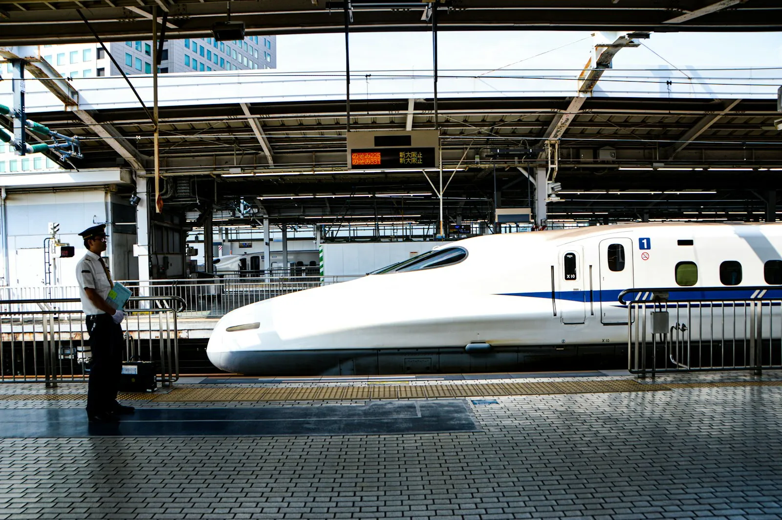 A white shinkansen bullet train waiting at a station platform in Japan