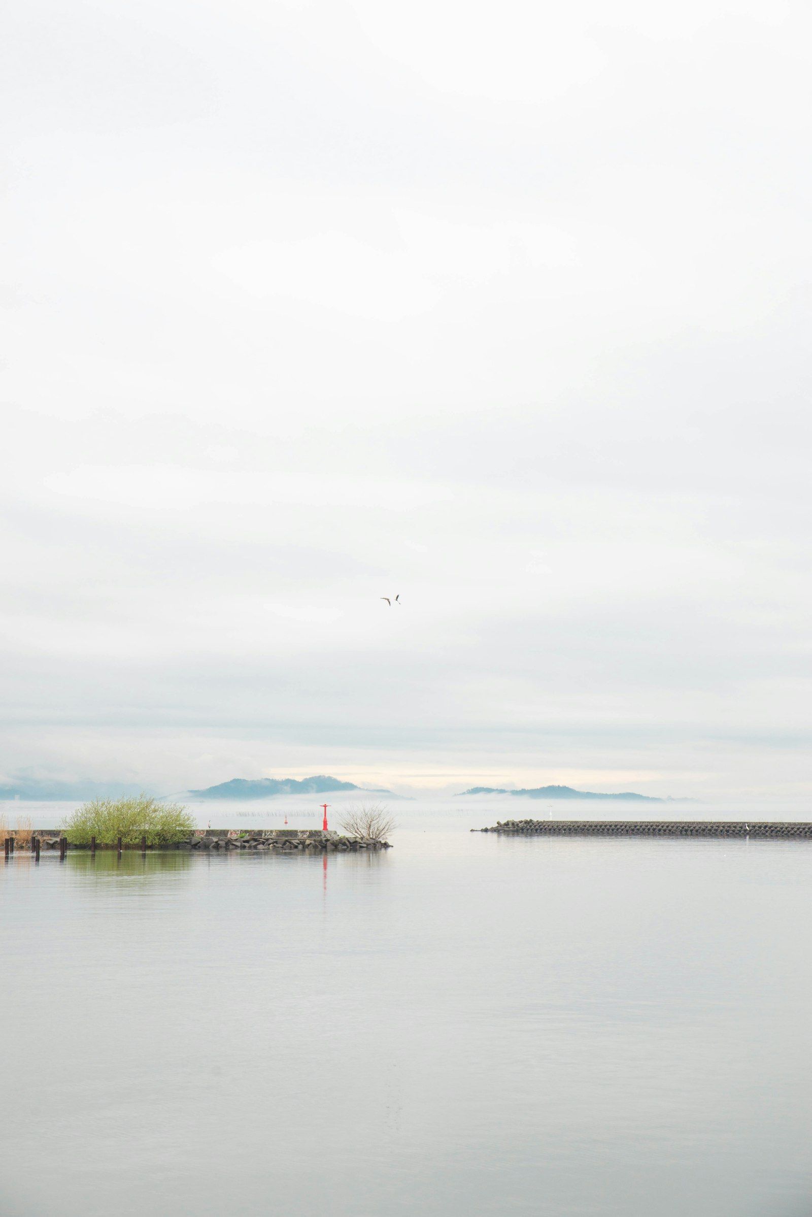 Calm water of Lake Biwa in Shiga with a small island on the horizon