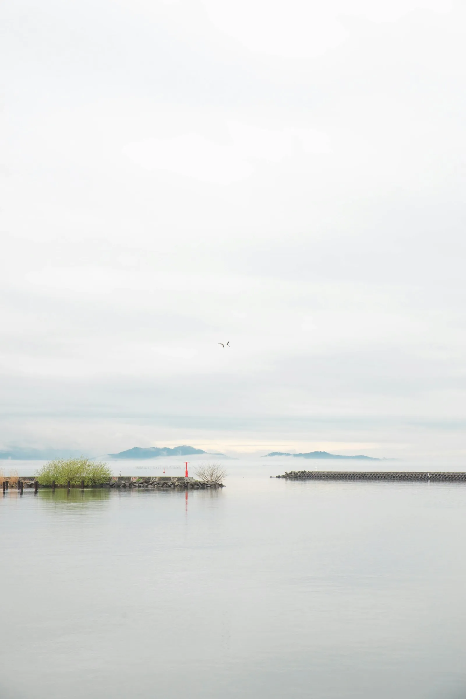 Calm water of Lake Biwa in Shiga with a small island on the horizon